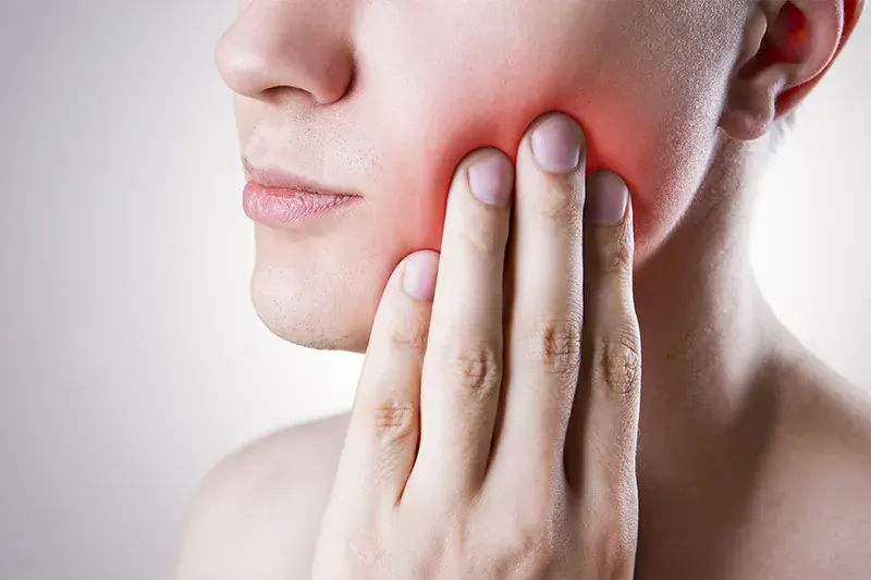 Patient touching jaw